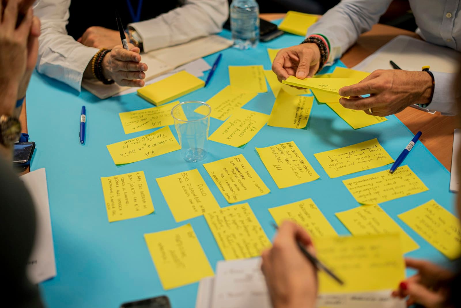 Hands sorting sticky notes in a workshop